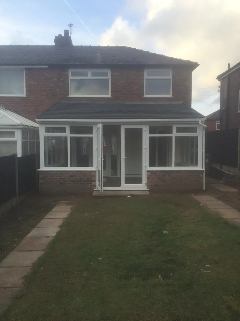 White uPVC conservatory with tiled roof and French doors