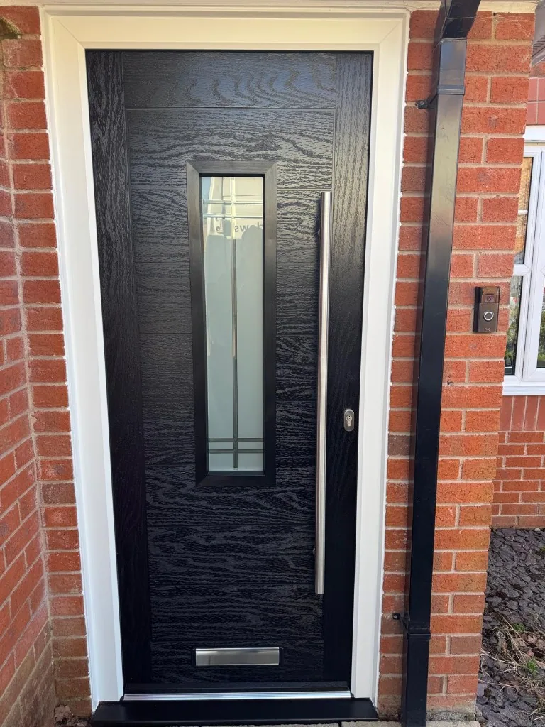 Black composite front door with vertical glazing and bar handle